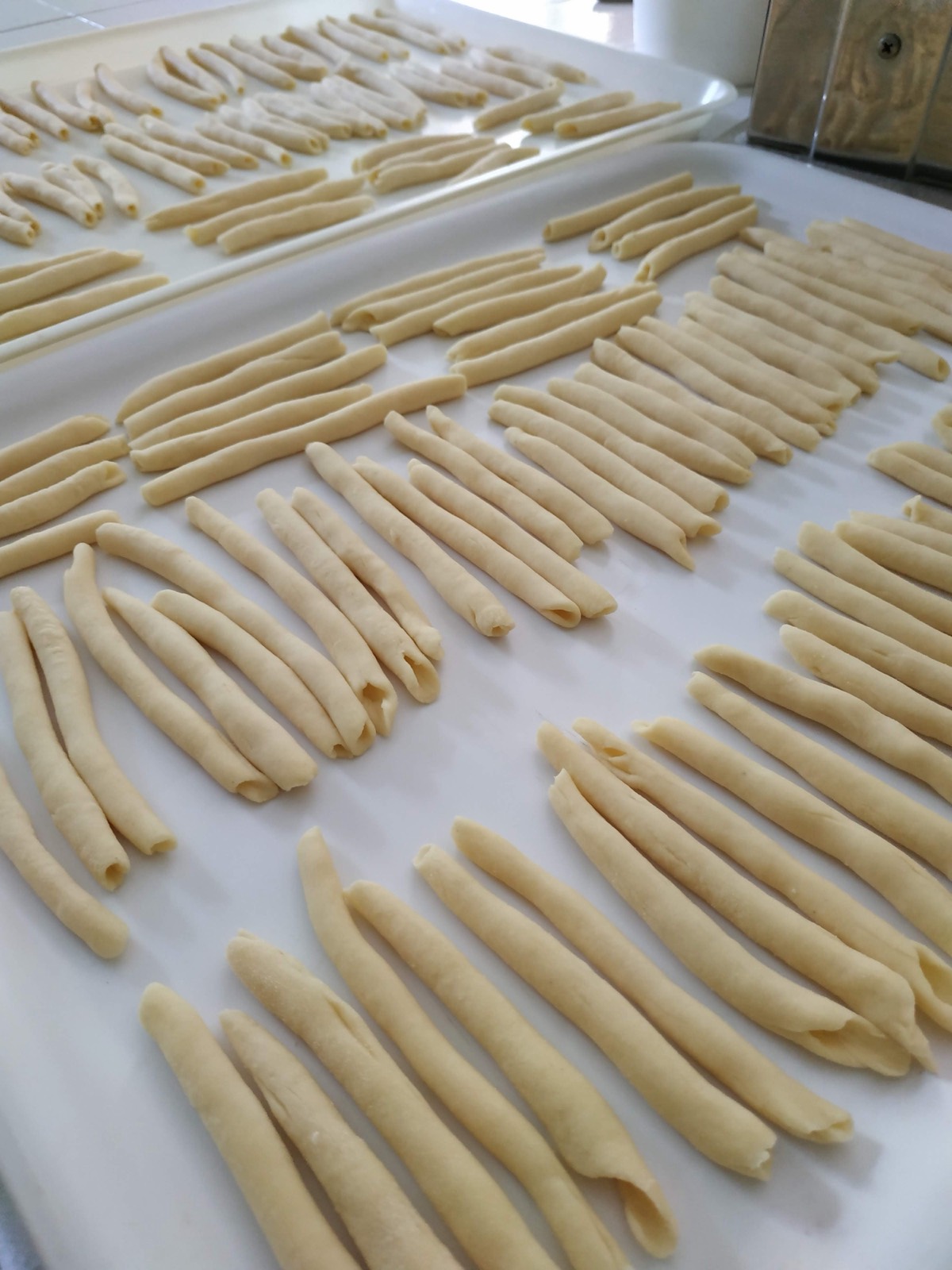 Rows of handmade fusilli on a floured board