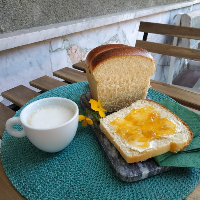 Brioche loaf with marmalade and a cup of milk for breakfast