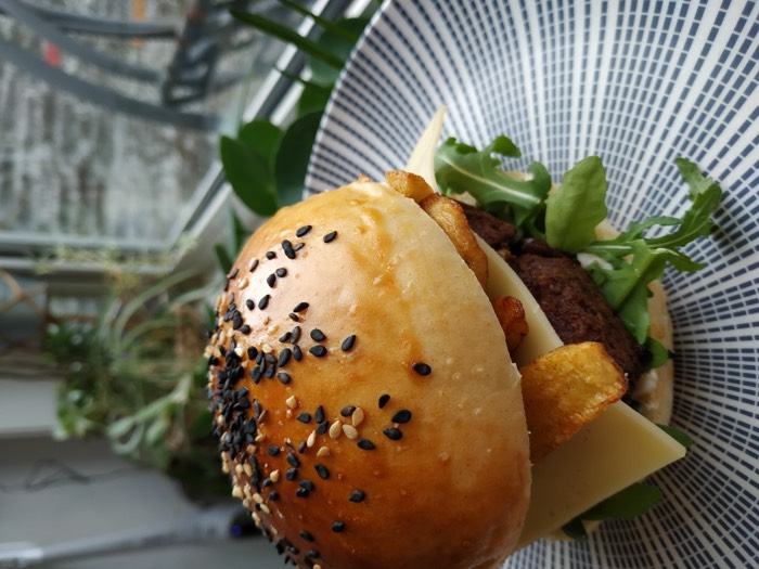A burger in a homemade sesame bun with rocket