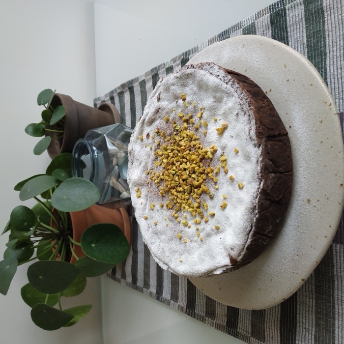 A chocolate cake topped with cream and bee pollen