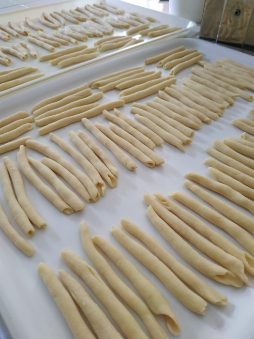 Rows of handmade fusilli on a floured board