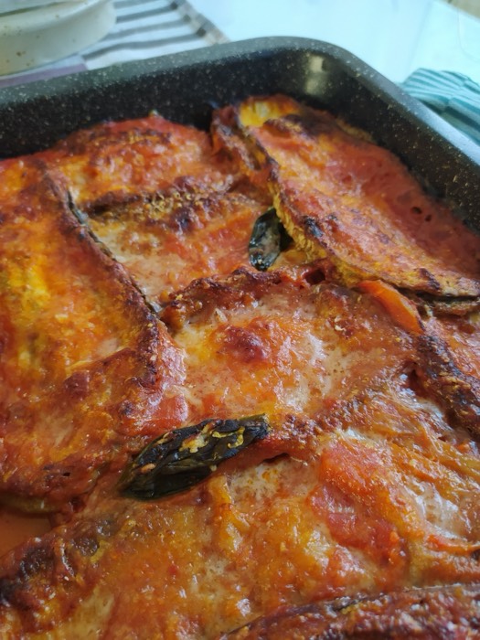 Close-up of a golden parmigiana in its tray