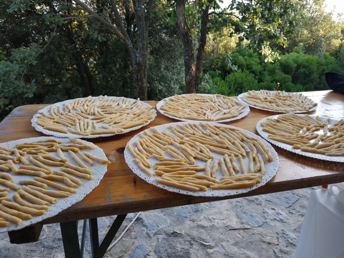 Trays of handmade pasta drying outdoors in the garden