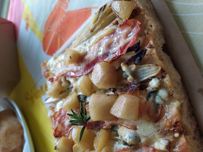 Pizza topped with potatoes, speck and rosemary