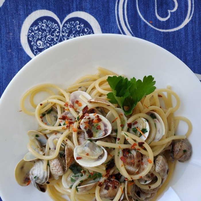Spaghetti with clams on a blue-patterned plate